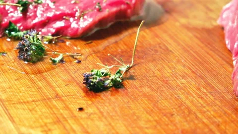 Raw beef for cooking steak. Bamboo board. Oregano and other spices. Bamboo board Stock Footage 88441262