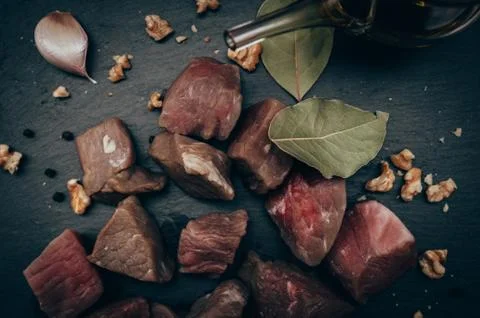 Raw Beef Cubes top view on black slate Stock Photos