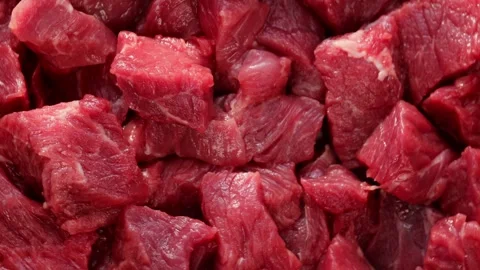 Raw beef cubes turning in slow rotation, showcasing rich red color and natural Stock Footage 310786660