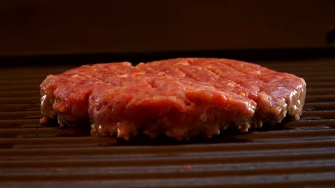 Raw beef cutlet for burger is frying on the grill outdoors Stock Footage 127643630