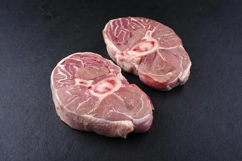 Raw beef leg slice with cross-section marbling as ossobuco offered as close-u Stock Photos