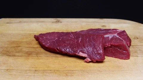 Raw beef meat on a black background Stock Footage 128284348