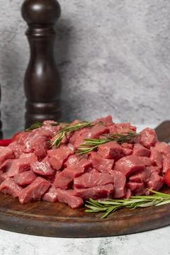 Raw beef meat chopped in cubes. Diced beef or lamb on a wooden serving board Stock Photos