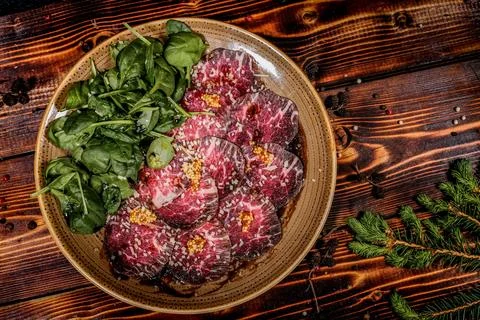 Raw Beef Meat studio shot plating idea on an elegant dark wood dinning set up Stock Photos