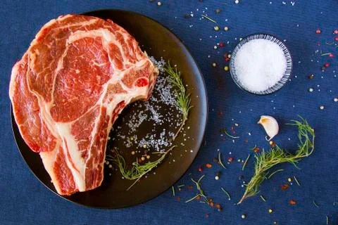 Raw beef meat on the table, spices and Rosemary, Rib eye steak ingredients. P Stock Photos