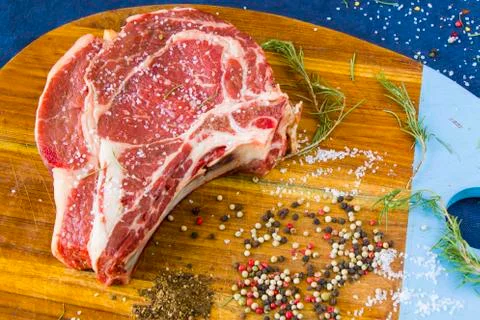 Raw beef meat on the table, spices and Rosemary, Rib eye steak ingredients. P Stock Photos