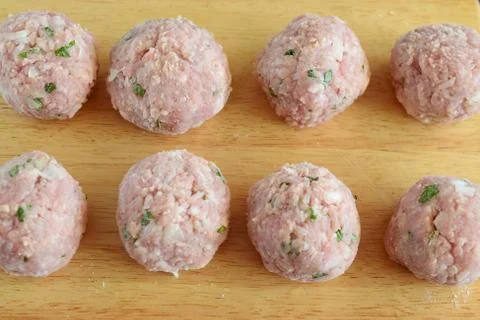 Raw beef meatballs with mint and rice on a wooden cutting board. Step by step Stock Photos