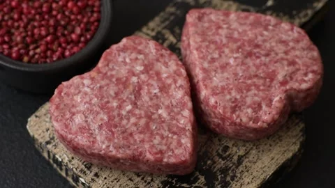 Raw beef or pork burger patty in the shape of a heart Video stock 300108573