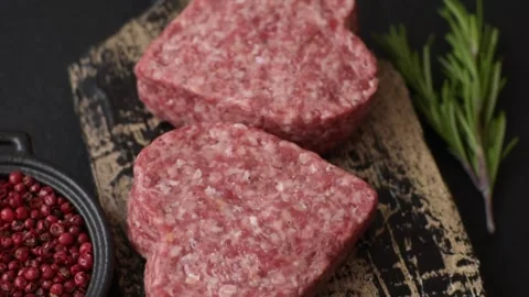 Raw beef or pork burger patty in the shape of a heart Video stock 300108577