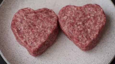 Raw beef or pork burger patty in the shape of a heart Video stock 300108593