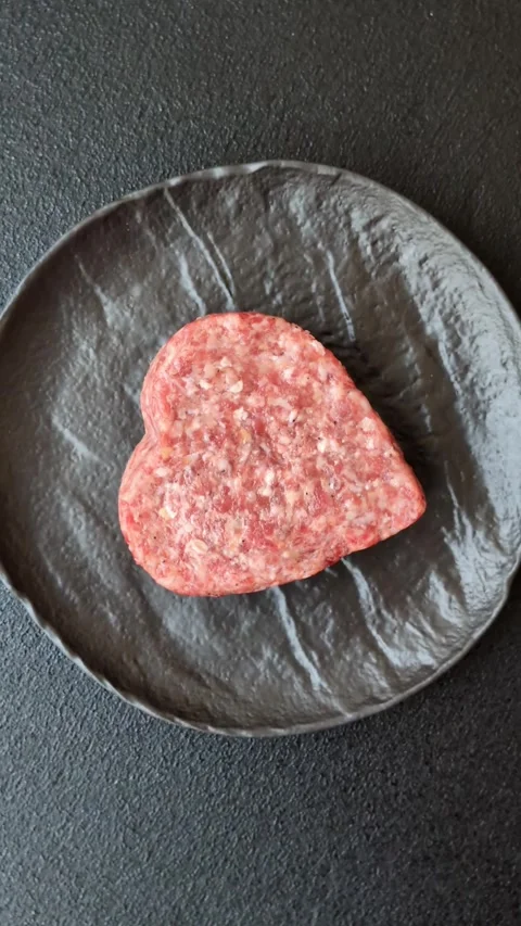 Raw beef or pork burger patty in the shape of a heart Video stock 300108689
