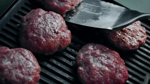 Raw beef patty placed onto a hot contact grill, 4K Stock Footage 341117339