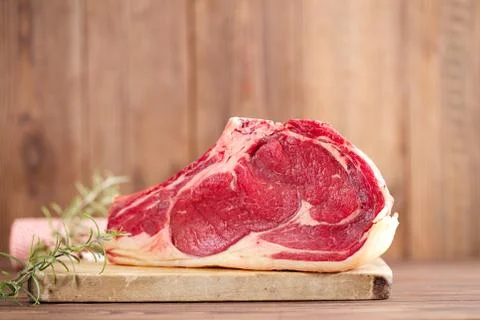 Raw beef Rib steak with bone on wooden board and table Stock Photos