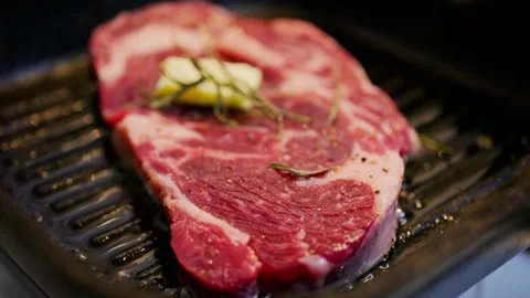 Raw beef ribeye steak searing on hot grill pan with butter and rosemary. Stock Footage 339764887