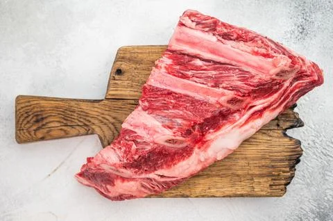 Raw beef ribs meat cut with bone structure and seasoning on board. Bright t.. Stock Photos