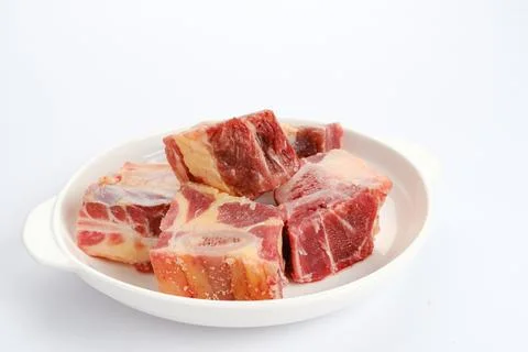 Raw beef ribs or daging iga sapi on white plate, food preparation. Stock Photos