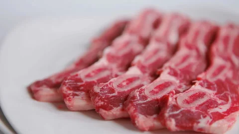 Raw beef ribs on white background, close up. Rotating plate Video stock 130406848