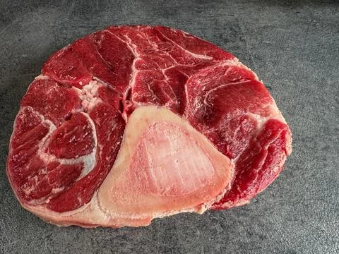 Raw beef shank cross-cut with bone on dark stone countertop, high-angle sid.. 스톡 사진