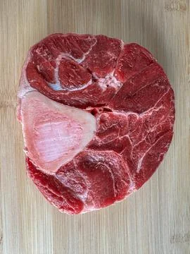 Raw beef shank cross-section with bone on wooden cutting board, detailed cl.. Stock-Fotos