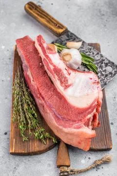 Raw beef soup bone with marrow and meat on rustic board with garlic and her.. Stock Photos