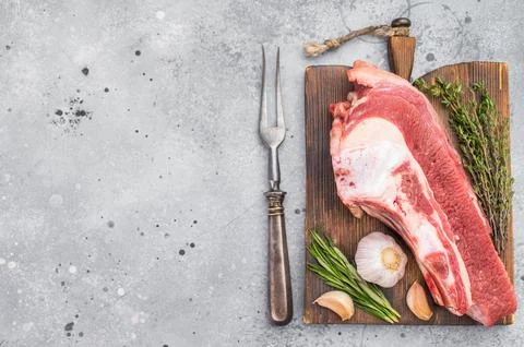 Raw beef soup bone with marrow and meat on rustic board with garlic and her.. Stock Photos