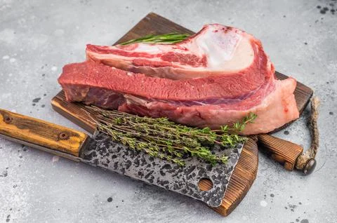 Raw beef soup bone with marrow and meat on rustic board with garlic and her.. Stock Photos