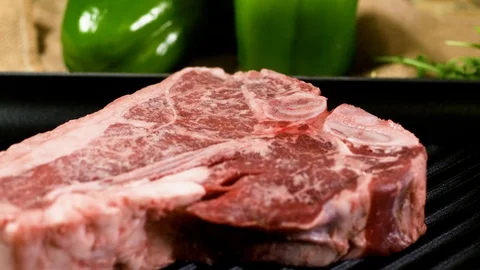 Raw beef steak on the black tray, panning close up shot Stockbeeldmateriaal 102609383
