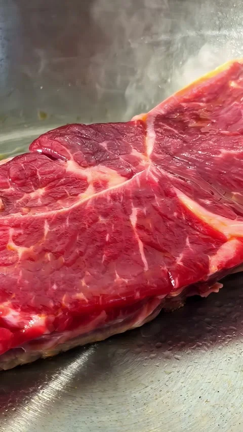 Raw Beef Steak Cooking in a Hot Stainless Steel Pan Stock Footage 339751739
