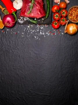 Raw beef steak on a cutting board with rosemary and spices. Stock Photos