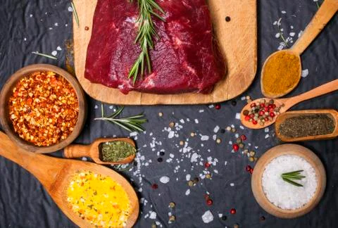 Raw beef steak on a cutting board with rosemary and spices. Foto stock
