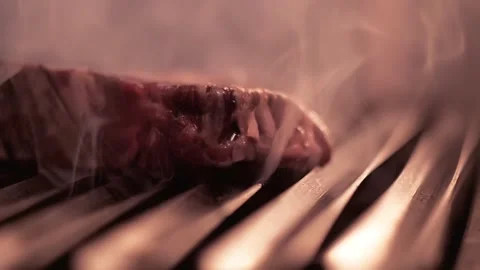 Raw beef steak falls on grill with burning fire and smoke. Stock Footage 156361693