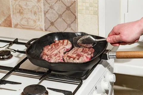 Raw beef steak in grill pan Stock Photos