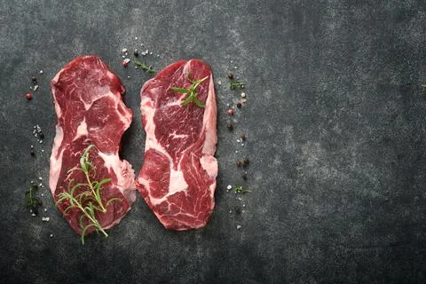 Raw beef steak. Marbled raw fresh Ribeye steak with rosemary, salt and pepper Stock Photos
