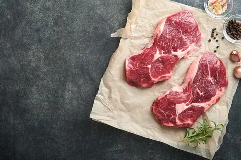 Raw beef steak. Marbled raw fresh Ribeye steak with rosemary, salt and pepper Stock Photos
