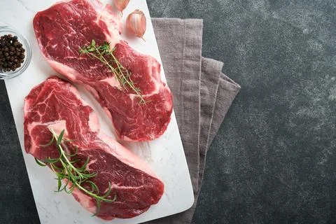 Raw beef steak. Marbled raw fresh Ribeye steak with rosemary, salt and pepper Stock Photos