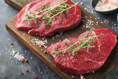 Raw beef steak. Marbled raw fresh Ribeye steak with rosemary, salt and pepper Stock Photos