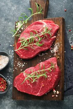 Raw beef steak. Marbled raw fresh Ribeye steak with rosemary, salt and pepp.. Stock Photos