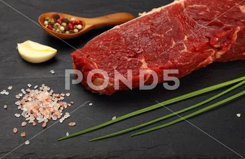 Raw beef steak meat cut and spices on black board Stock Photos