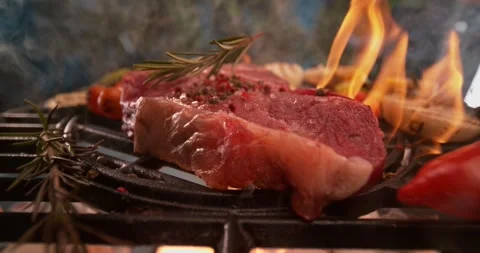 Raw beef steak on outdoor grill with dynamic flames and smoke. Stock Footage 337448266