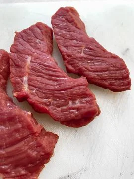 Raw beef steak presented on a white surface Stock Photos