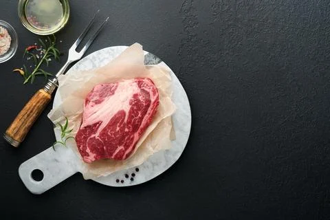 Raw beef steak. Raw fresh Chuck roll steak with rosemary, salt and pepper o.. Stock Photos