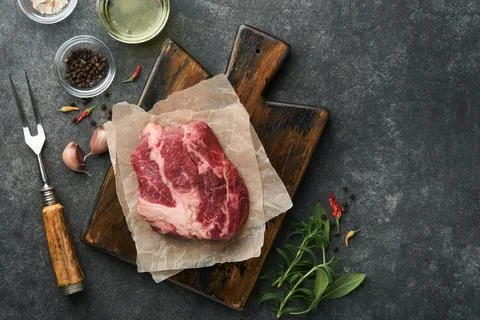 Raw beef steak. Raw fresh Chuck roll steak with rosemary, salt and pepper on  Stock Photos