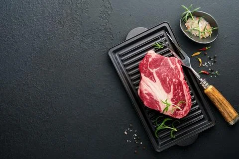 Raw beef steak. Raw fresh Chuck roll steak with rosemary, salt and pepper on  Stock Photos
