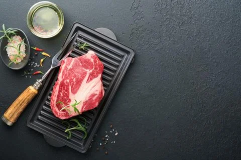 Raw beef steak. Raw fresh Chuck roll steak with rosemary, salt and pepper on  Stock Photos