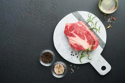 Raw beef steak. Raw fresh Chuck roll steak with rosemary, salt and pepper on  Stock Photos