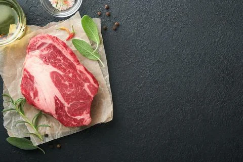 Raw beef steak. Raw fresh Chuck roll steak with rosemary, salt and pepper on  Stock Photos