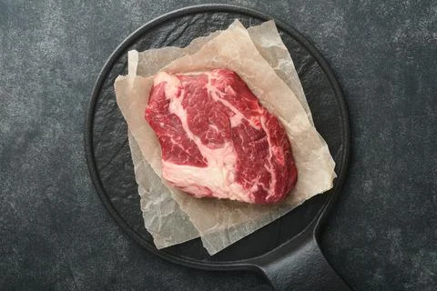 Raw beef steak. Raw fresh Chuck roll steak with rosemary, salt and pepper on  Stock Photos