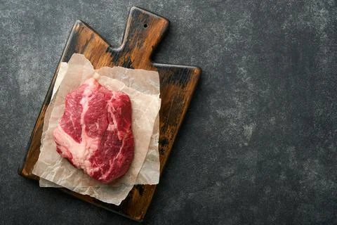 Raw beef steak. Raw fresh Chuck roll steak with rosemary, salt and pepper on  Stock Photos