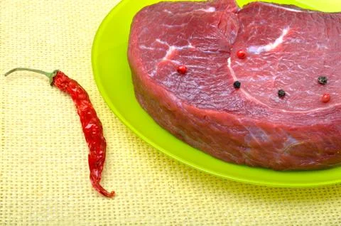 Raw beef steak with red pepper. Stock Photos