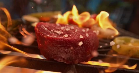 Raw beef steak sizzling on grill with large salt crystals falling in slow m.. Stock Footage 337484125